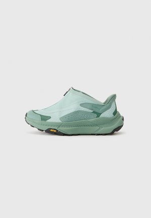 Grønn slip-on sko med strukturert mesh-overdel, forsterkede detaljer og sort Vibram-såle. Har glidelås for enkel påkledning.