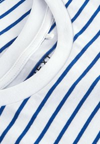 Camicia bianca di cotone con sottili strisce orizzontali blu e una vista ravvicinata del suo collo rotondo e dell'etichetta interna.