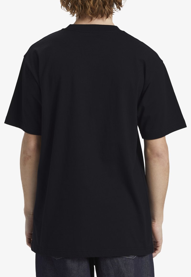 T-shirt en coton noir avec un col rond, des manches courtes et une coupe décontractée. Le dos présente une surface lisse et sans ornement.