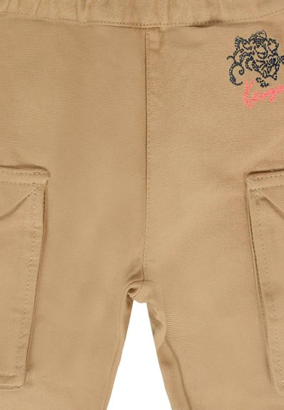 Pantalons cargo beiges avec une texture lisse, comportant des poches latérales et un motif de broderie décorative noir et rose.