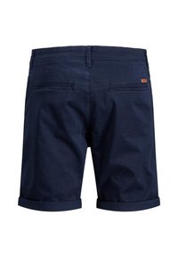 Shorts en coton bleu marine avec des ourlets retroussés, comportant deux poches arrière et une petite étiquette de marque près de la taille. Tissu texturé.