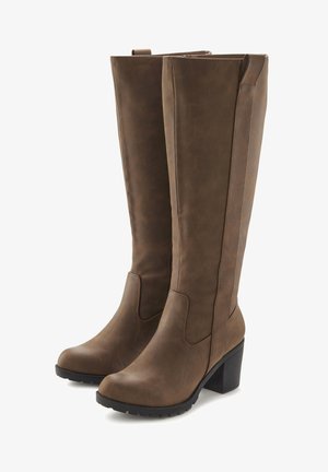 Botas altas de cuero sintético marrón con tacón grueso. Presentan una textura suave, detalles de costura y una puntera redondeada.