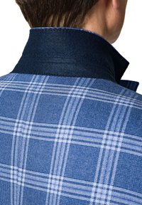 Niebieska kratkowana kurtka z kołnierzem w ciemnoniebieskim kolorze. Posiada teksturowany wzór w jasnoniebieskie i białe linie.