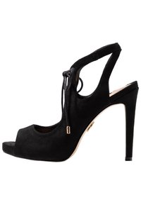 Czarne zamszowe sandały na wysokim obcasie z odkrytym palcem, zapięciem typu slingback oraz ozdobnym sznurowaniem z złotą końcówką na białym tle.