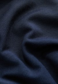 Granatowy materiał, teksturowany dzianiną z delikatnym prążkowaniem. Miękka, lekko elastyczna tkanina, ukazująca gładką powierzchnię i subtelny połysk.