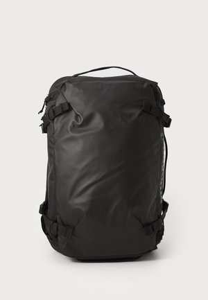 Black durable backpack with compression straps on sides and top handle, standing upright on a plain white background.