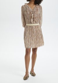 Lätt klänning med mönster, volangkrage, långa ärmar och elastisk midja. Mjukt tyg i creme, lila och röda toner; inkluderar beige bälte.