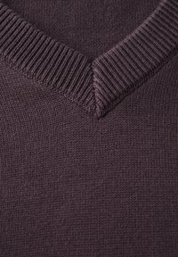 V-ringad pullover i djup lila, stickad textur, ribbad mudd och fåll; slät tyg med tät väv och jämn färg.