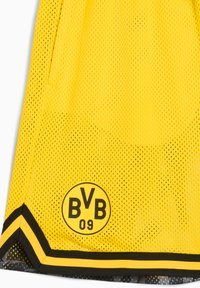 Gul mesh sportsjersey med sort trim og et cirkulært logo med "BVB 09." Designet inkluderer synlige ventilationhuller og lommer.
