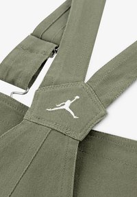 Zelene ženske naramenice od kordura s metalnim kopčama i dijamantnim oblogom s bijelim Jumpman logotipom. Teksturedna površina i čvrst dizajn.