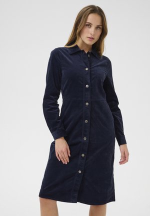 Navy corduroy shirt dress with a button-down front, long sleeves, and a classic collar. Smooth texture, knee-length cut, and silver buttons.