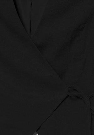 Vêtement noir style portefeuille avec un lien en tissu sur le côté, doté d'un col en V et d'un matériau texturé.