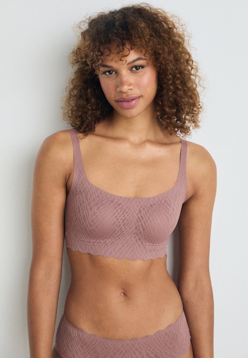 Mauve bh met brede banden, geschulpte randen en een textuurdesign dat lijkt op geometrische patronen, gemaakt van een zachte stof.