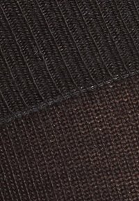 Tecido de malha preta com textura canelada na parte superior e textura mais lisa abaixo, com cor consistente em todo o tecido.