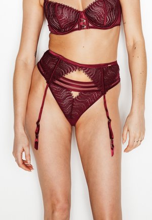 Set di lingerie color bordeaux composto da un reggiseno in pizzo con ferretto e slip a vita alta con pannelli trasparenti e dettagli decorativi in metallo.