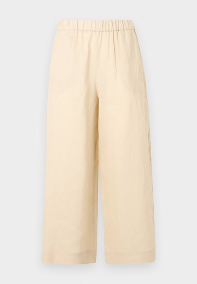 Παντελόνια σε φαρδιά γραμμή σε μπεζ χρώμα με ελαστική μέση και χωρίς ορατές τσέπες, παρουσιάζονται σε απλό ανοιχτό φόντο.