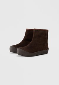 Brune suède ankelsko med en teksturert grå gummisåle og brune detaljer, med et enkelt design og uten synlige lisser eller maskinvaredetaljer.