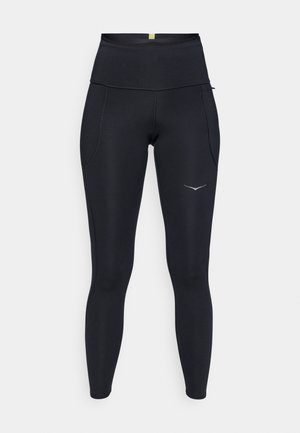 Leggings atléticos negros con una cintura alta. Hechos de material elástico, con dos bolsillos laterales y detalle de logo reflectante.
