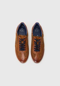 Baskets en cuir marron et en daim avec des accents de doublure bleue, bout rond et lacets navy. Présente une texture subtile et un détail de logo.