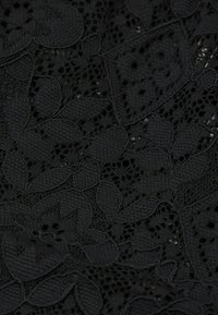 Schwarzer Spitzenstoff mit floralen Mustern und filigranen Netzdetails, mit einer sanften Textur und unterschiedlichen Transparenzgraden.