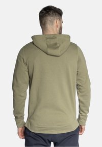 Oliwkowy hoodie z kapturem na sznurki, ribkowanymi mankietami i teksturowanym materiałem. Posiada kieszeń typu kangur na przodzie i luźny krój.