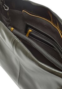 Grå läderhandväska med dragkedja, inre fack och guldfärgad hardware. Mjuk textur med slät finish, elegant design.