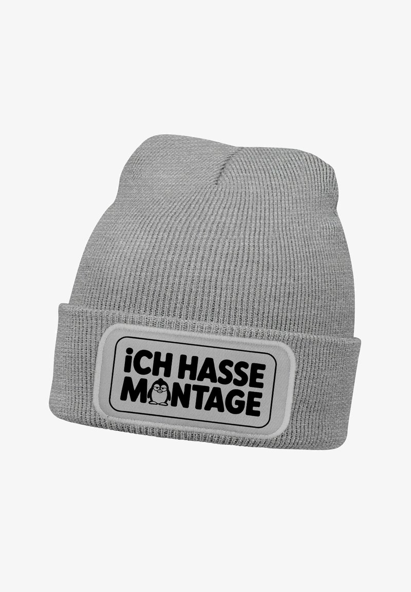 Gray knit beanie with a folded cuff, featuring a rectangular patch that reads "iCH HASSE MONTAGE" in black text and includes a cartoon penguin.