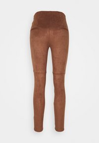 Bruine, gestructureerde, hooggetailleerde legging zonder zichtbare sluitingen of zakken, ontworpen met een aansluitende snit. Glad, rekbaar materiaal.