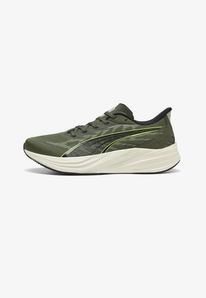 Olivgrüner Laufschuh mit schwarzem und gelbem Seitenstreifen, Mesh-Obermaterial, schwarzen Schnürsenkeln und dicker weißer gepolsterter Sohle.