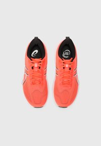 Bright pink athletic shoes with a mesh fabric upper, black insoles, round toe, and contrasting white accents along the sides and laces.