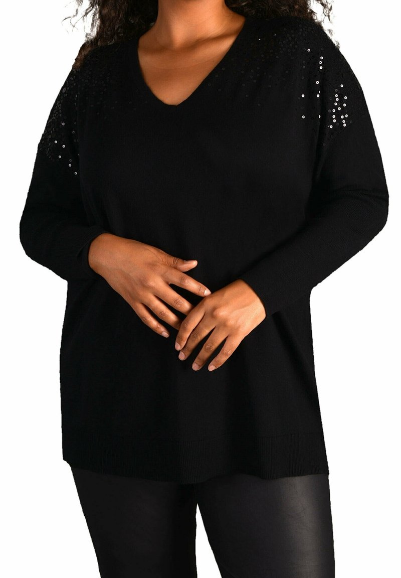 Svart stickad tröja med V-ringning, dekorerad med svarta paljetter på axlarna, med långa ärmar och en avslappnad passform.