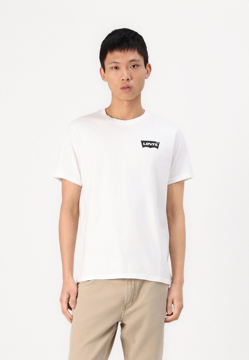 Tricou din bumbac alb, cu un logo negru Levi's pe pieptul stâng. Mâneci scurte și guler rotund. Textură subtilă.