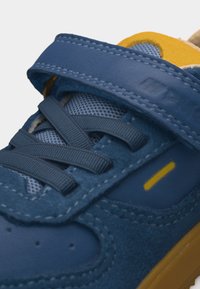 Μπλε και κίτρινο αθλητικό παπούτσι με διχτυωτό ύφασμα, ραμμένα πάνελ από σουέτ, ελαστικά κορδόνια και κλείσιμο με λουράκι αυτοκόλλητο (hook-and-loop).