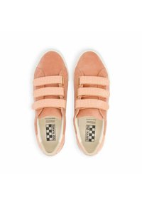 Baskets en suède rose clair dotées de trois bandes Velcro texturées, d'accents dorés et d'une semelle en caoutchouc blanc avec une semelle intérieure à carreaux.
