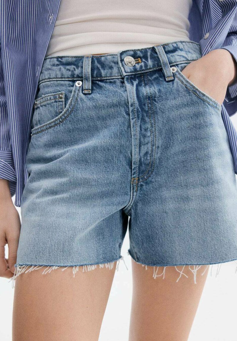 Pantaloni scurți de blugi albastru deschis, cu talie înaltă, tiv franjurat și design clasic cu cinci buzunare. Închidere cu nasturi și bucle pentru curea disponibile.