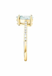 Anello d'oro con grande pietra azzurra chiara, con una fascia texturizzata e piccole pietre trasparenti incastonate su un lato.