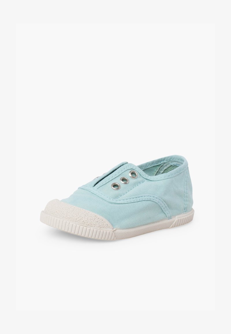 Baskets en toile bleu clair sans lacets avec semelle en caoutchouc blanche et embout, avec trois œillets métalliques sur le dessus.