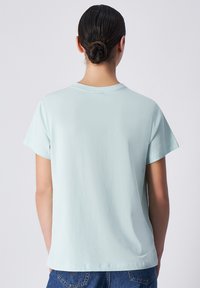 Lichtblauwe t-shirt met korte mouwen en een ronde halslijn, gemaakt van zachte stof. Eenvoudige, relaxte pasvorm, zonder zichtbare patronen of accenten.