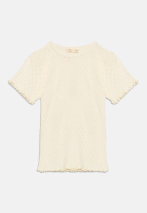 Short-sleeve cream knit top with subtle diamond pattern, round neckline, and ruffled edges on sleeves and hem.