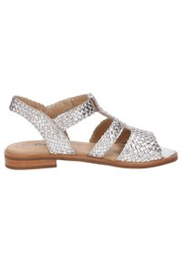 Silberne geflochtene Sandalen mit offener Zehe und seitlichen Riemen. Sie verfügen über eine flache, holzähnliche Sohle und glatte metallische Akzente.