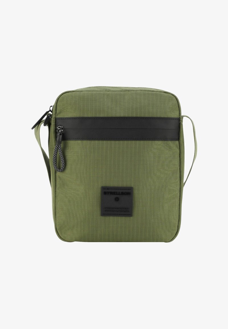 Borsa crossbody in tessuto verde con una striscia in pelle nera liscia, tracolla regolabile e una tasca frontale con patch logo. Forma rettangolare piatta.