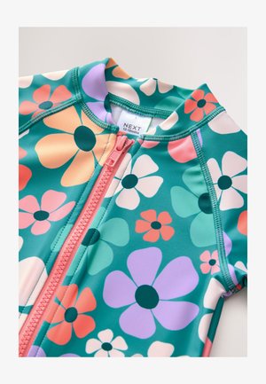 Dječji kupaći kostim u tirkiznoj boji s velikim cvjetnim uzorkom u ružičastoj, breskvastoj, ljubičastoj i zelenoj boji. Ima prednji patentni zatvarač i kratke rukave.