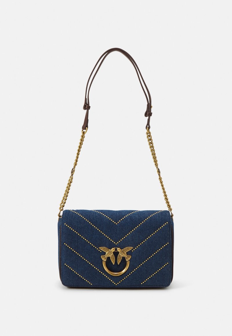 Sac à bandoulière en denim bleu avec motif chevron clouté doré, fermoir oiseau doré et sangle chaîne avec détail en cuir en haut.