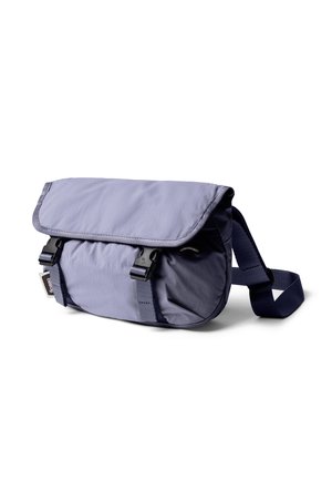 Petit sac bandoulière bleu marine avec rabat sécurisé par deux boucles noires à libération rapide et bandoulière réglable.