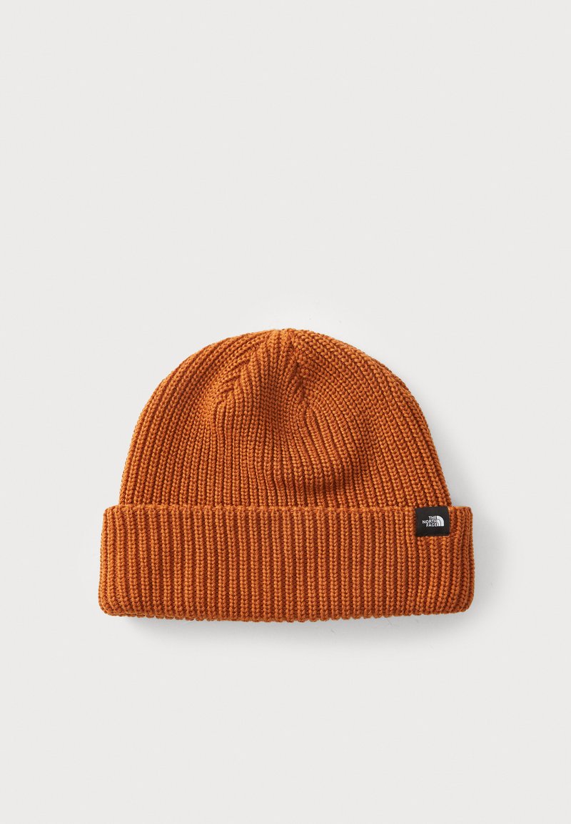 Knitted beanie in orange, featuring a ribbed texture and a folded cuff. Includes a small black brand tag on the side.