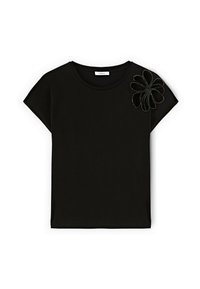 Sort kortærmet t-shirt lavet af bomuld med rund halsudskæring. Har en blomsterapplikation i en kontrasterende tekstur på den ene skulder.