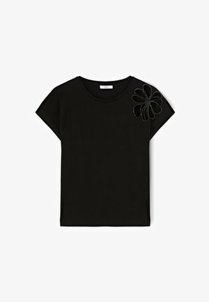 Tricou negru cu mânecă scurtă, din bumbac, cu guler rotund. Prezintă un aplicat floral dintr-o textură contrastantă pe un umăr.