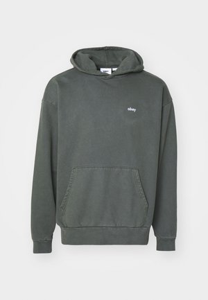 Sudadera de color verde oliva hecha de algodón, con un bolsillo tipo canguro y un pequeño logo blanco "obey" en el pecho. Textura suave y ajuste relajado.