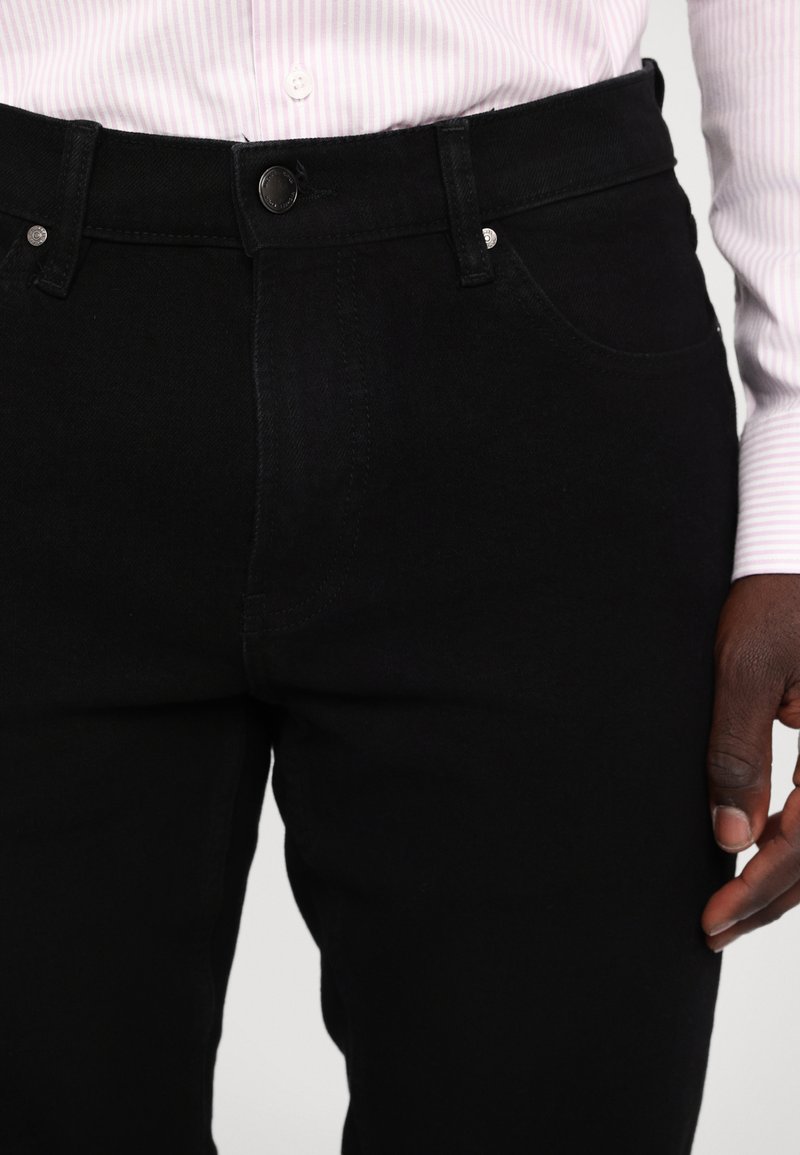 Schwarze Jeanshose mit mittelhoher Taille, Knopfverschluss, zwei Vordertaschen und einer glatten, unbeschädigten Struktur.