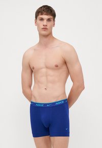 Herrens boxerbriefs i enhetlig marinblå, med en bred elastisk midjeband med ljusblå "NIKE"-logotyp och en stödjande kupa-design.